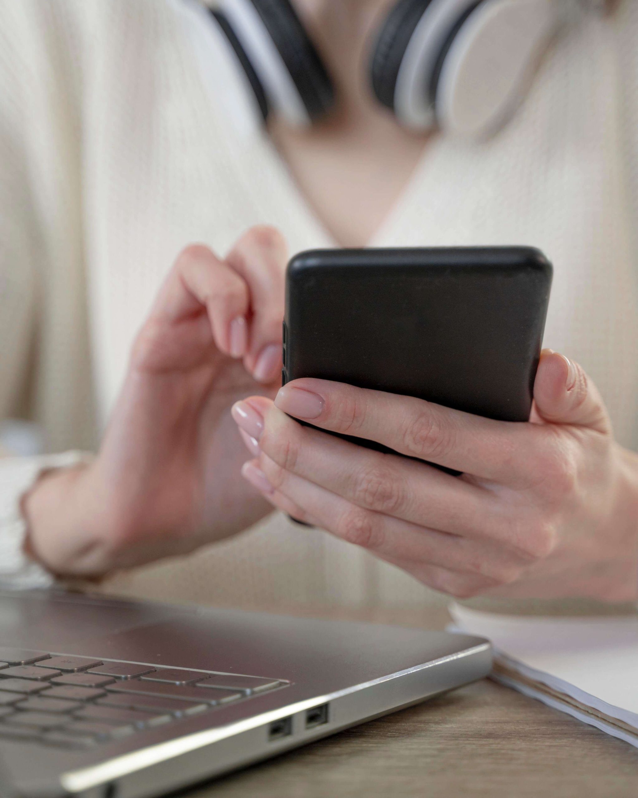close-up-woman-using-smartphone-laptop-1-OL5Y7PCAEq0BMBjhrvjM